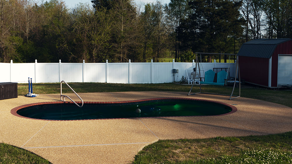 backyard pool with green light in it