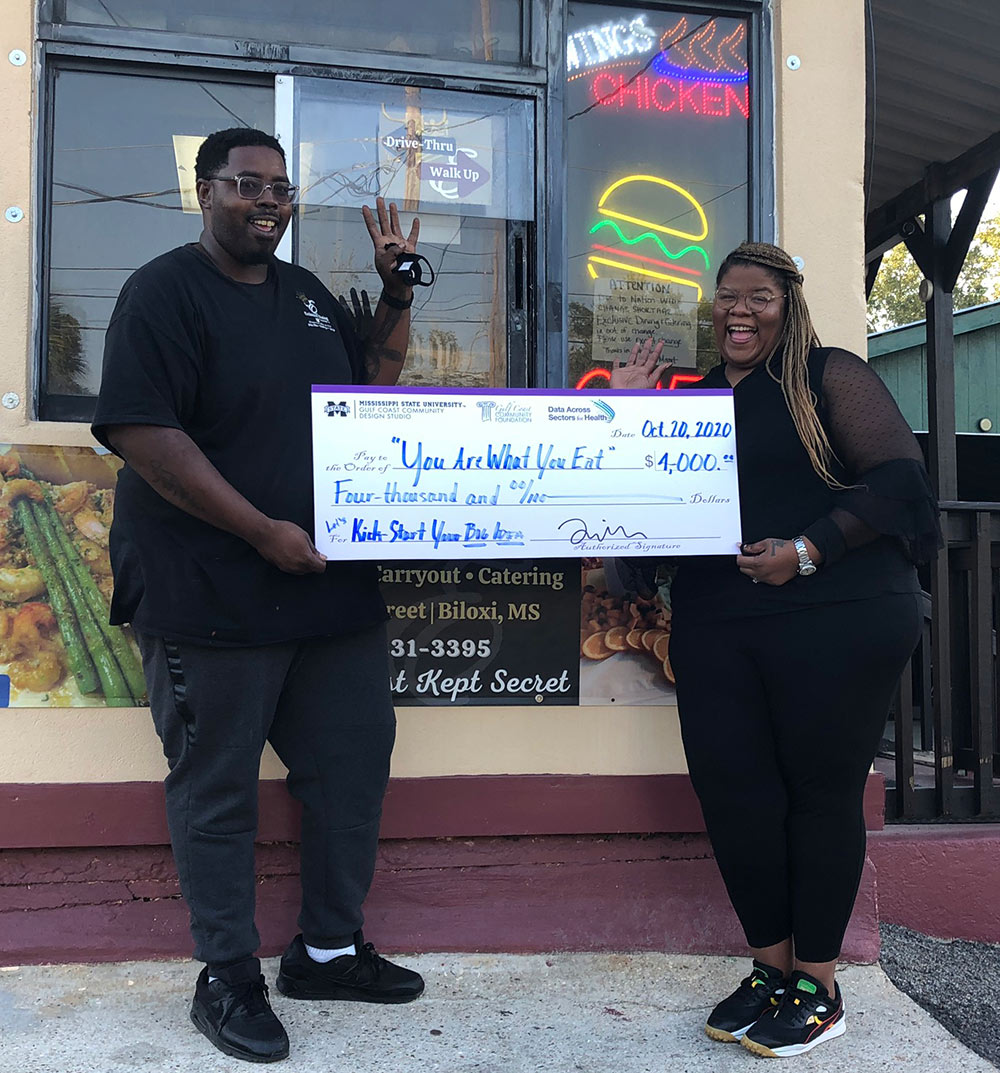 Chef Sherman Kyse, left, holds a check with Brandy Kyse