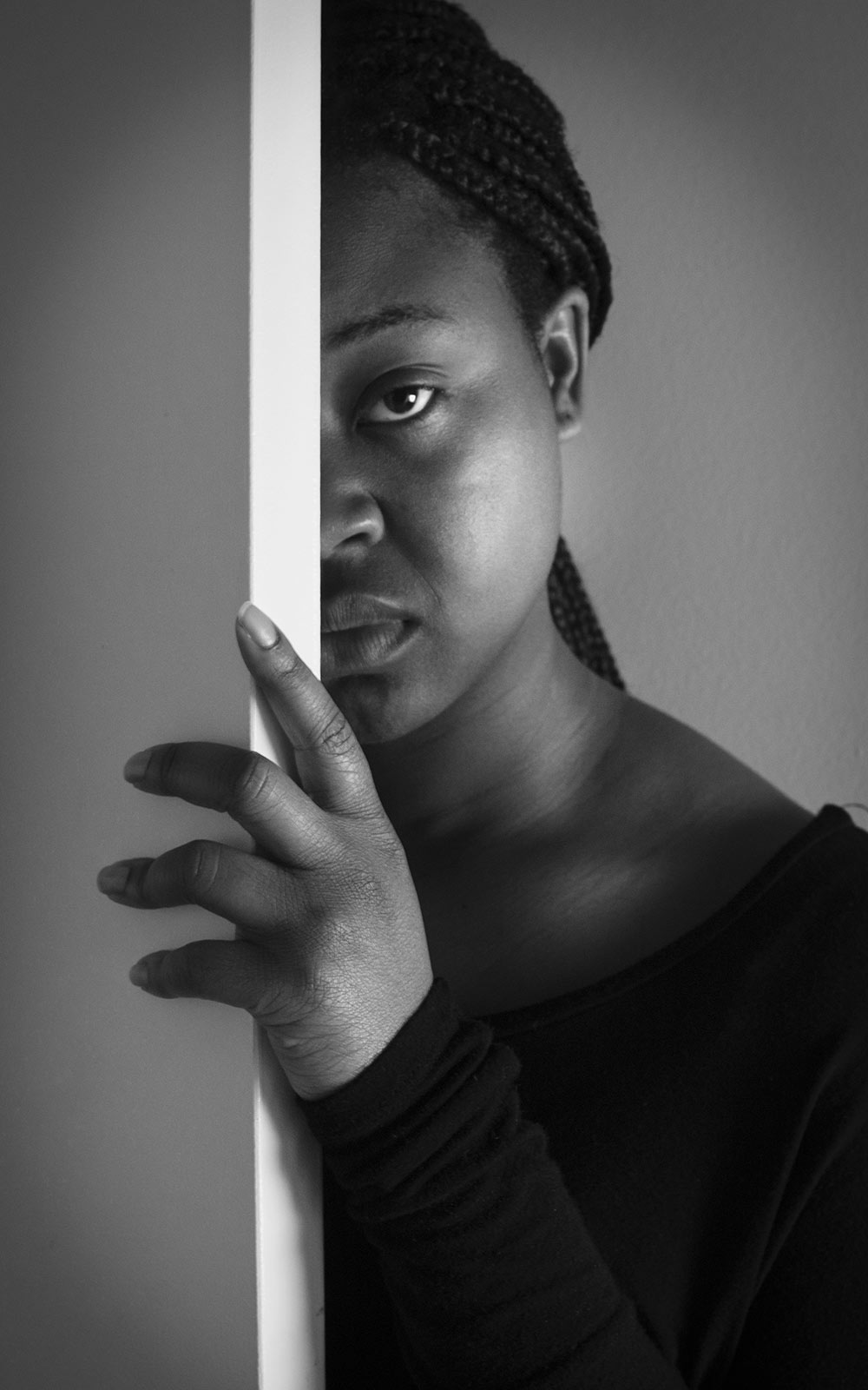 black and white shot of female on one side of door