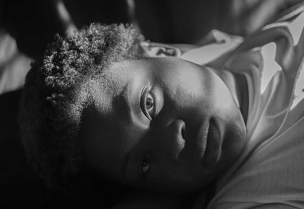 black and white shot of female face laying down looking into camera