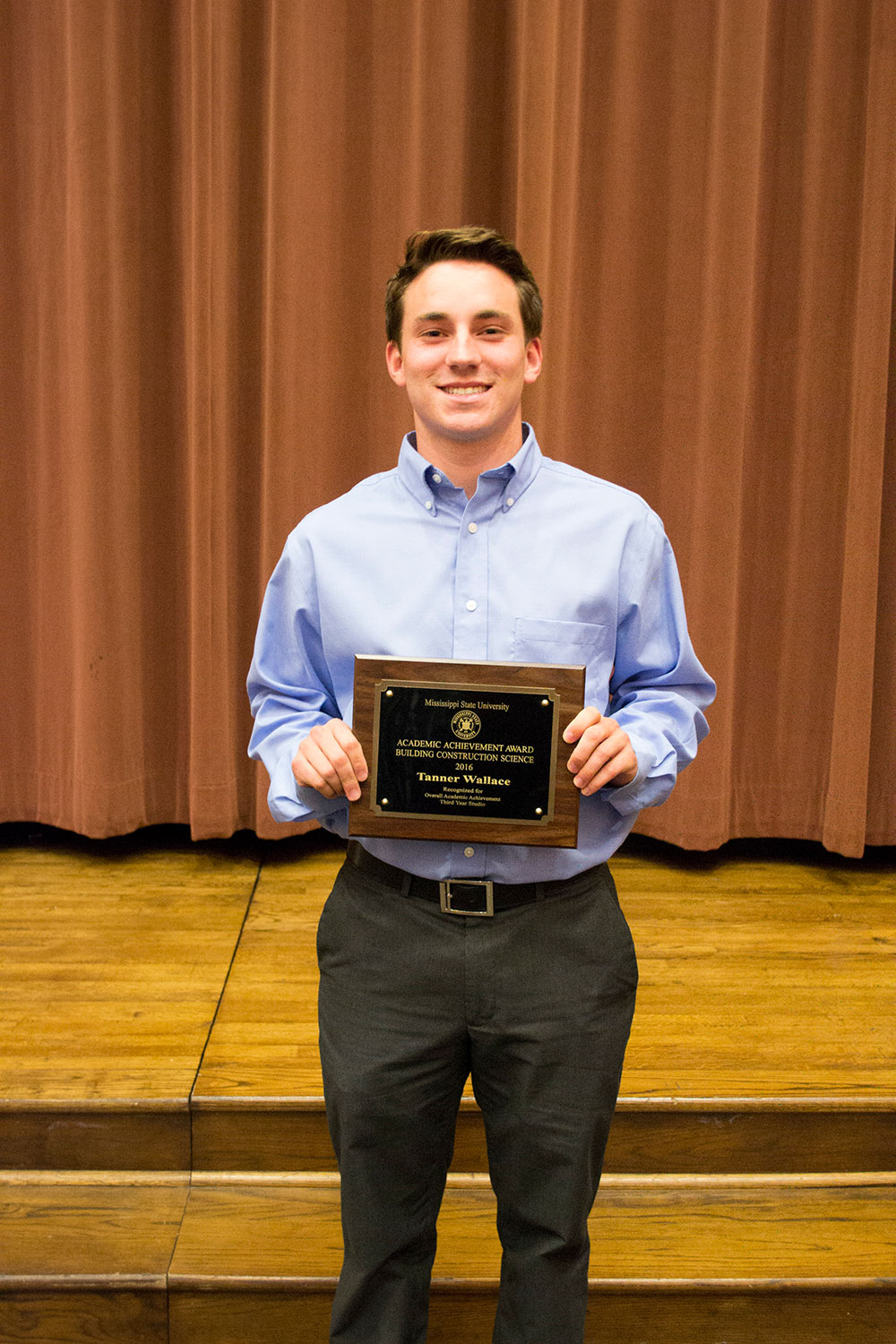 Tanner Wallace holds plaque