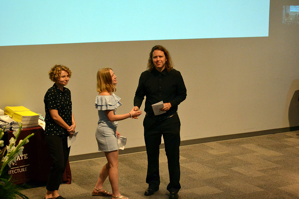 The TSD student president shakes hands with Professor Duane McLemore, right