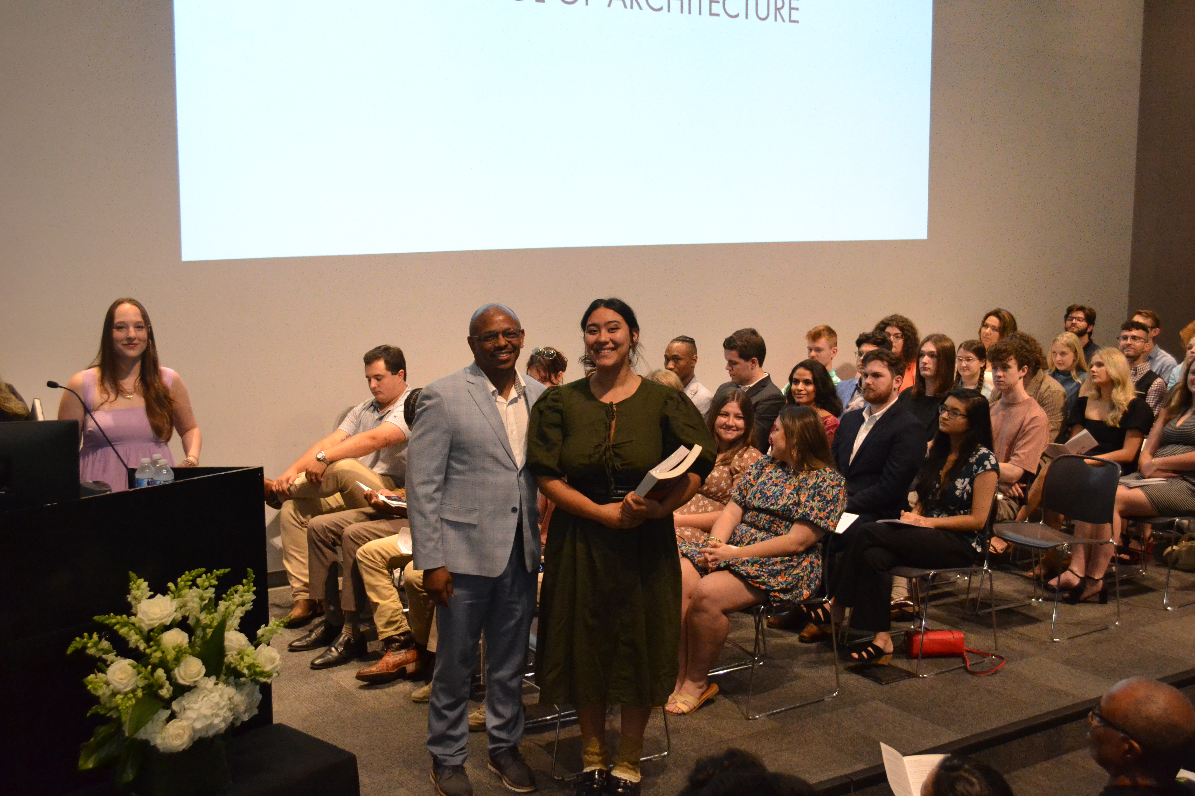 Instructor Ryan Ashford stands with a third-year book award recipient