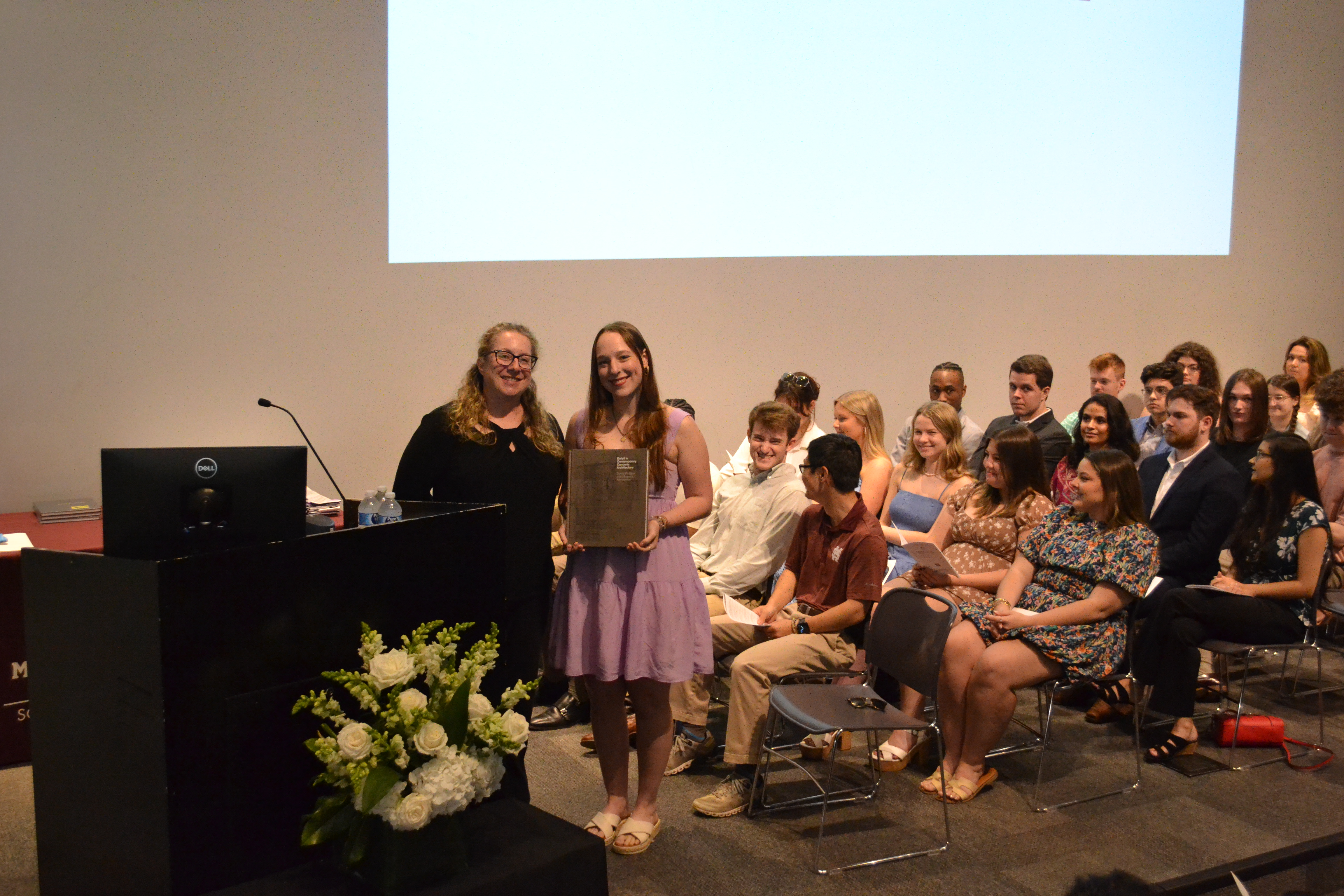 Associate Professor Alexis Gregory stands with a third-year book award recipient