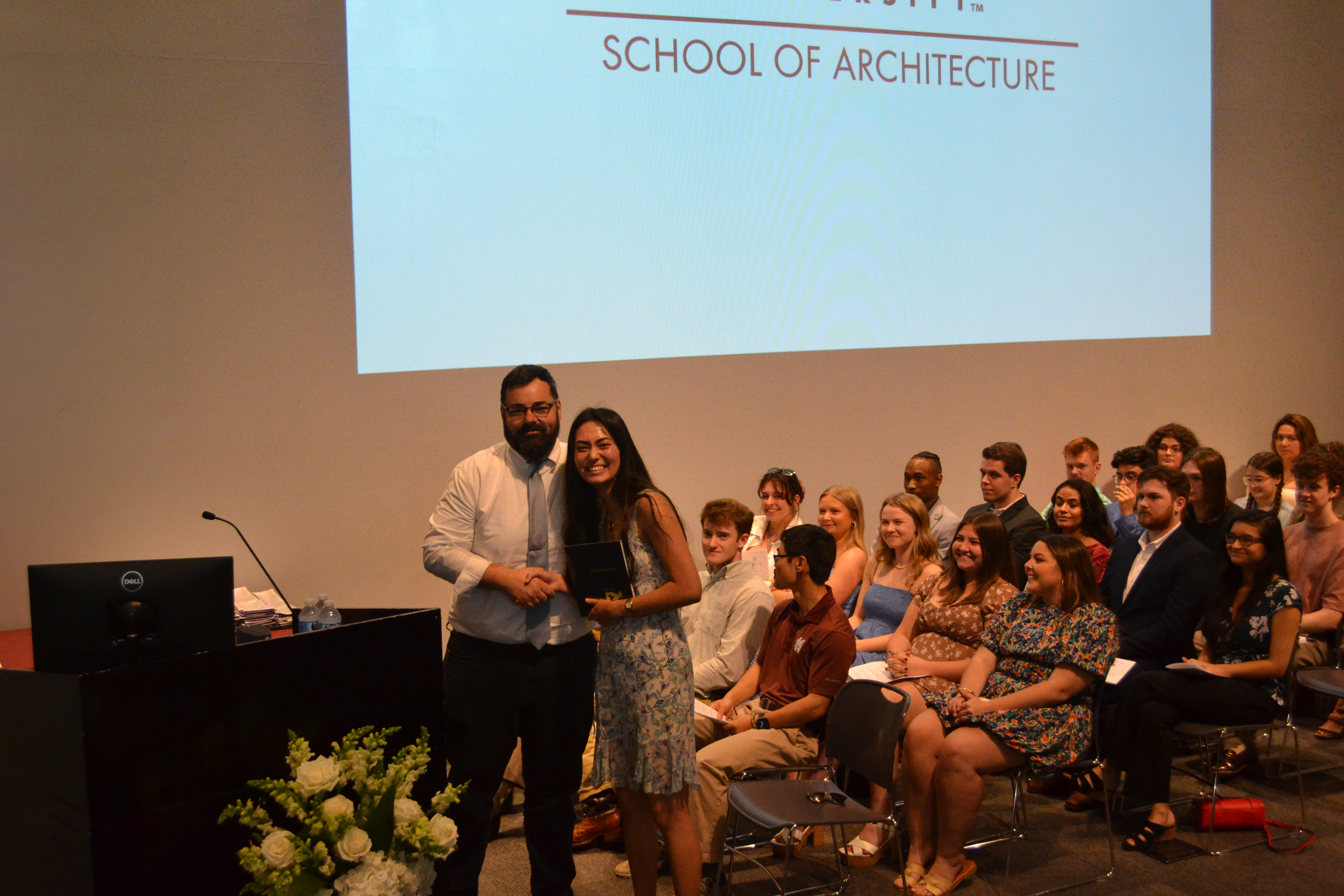 Professor Hans Herrmann stands with a fourth-year book award recipient