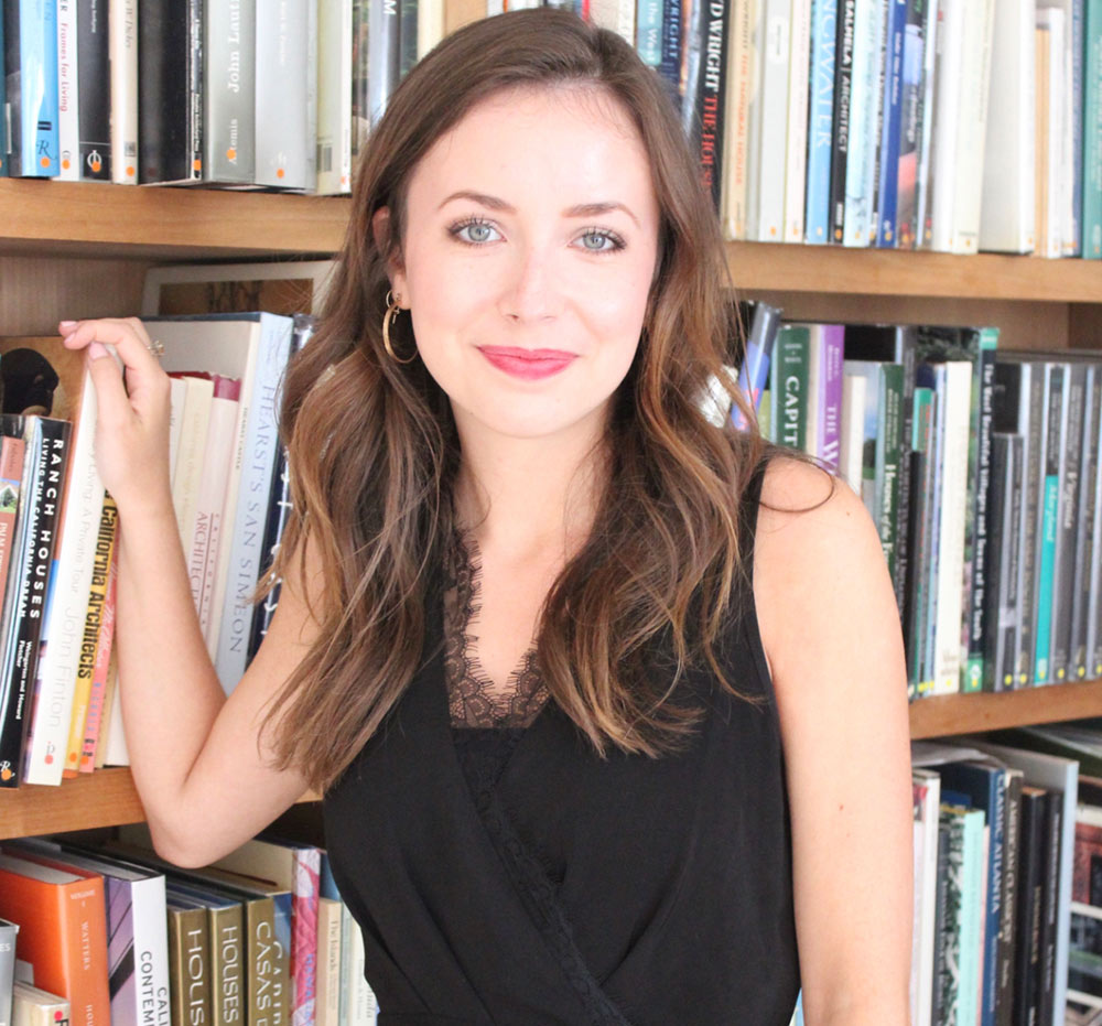 Meredith Hutto poses in front of book shelf