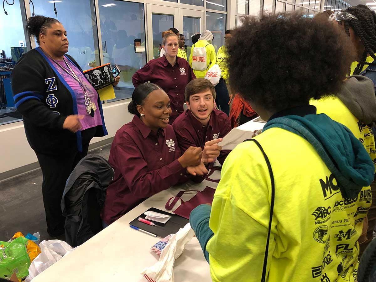 BCS students explain their tape measure challenge to a large group of the students who attend the career fair (in yellow shirts) 