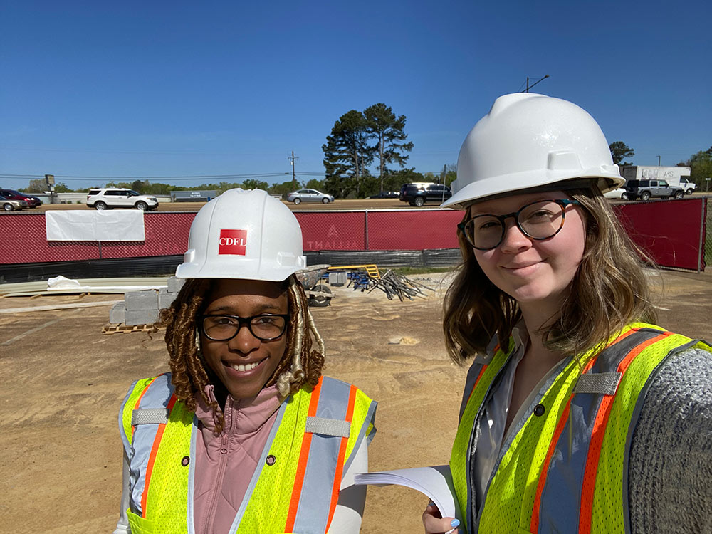 two students in construction PPE on job site