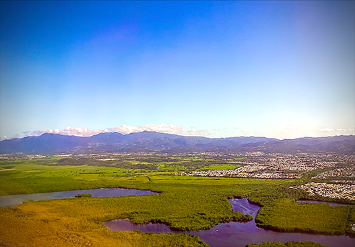 Photograph of mountains, river, land viewed from the sky.