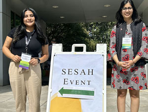 Jacqueline Enriquez, left, and Sapna Patlolla pose with SESAH sign