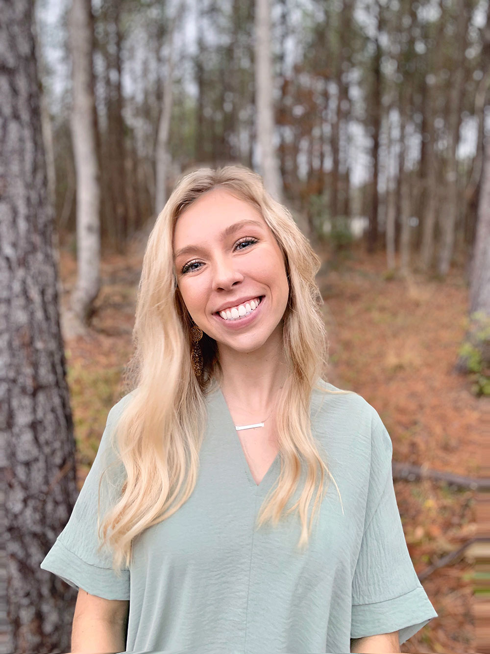 Sheridan Morris stands in woods