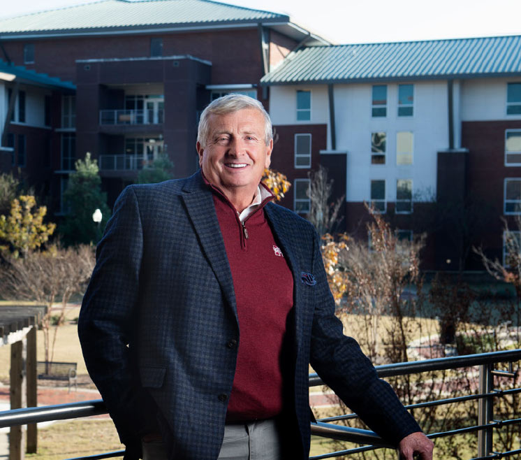 Bob Luke poses with Mississippi State University campus buildings in background