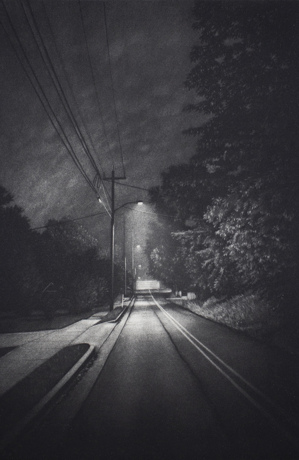 Black and white image of a street at night.