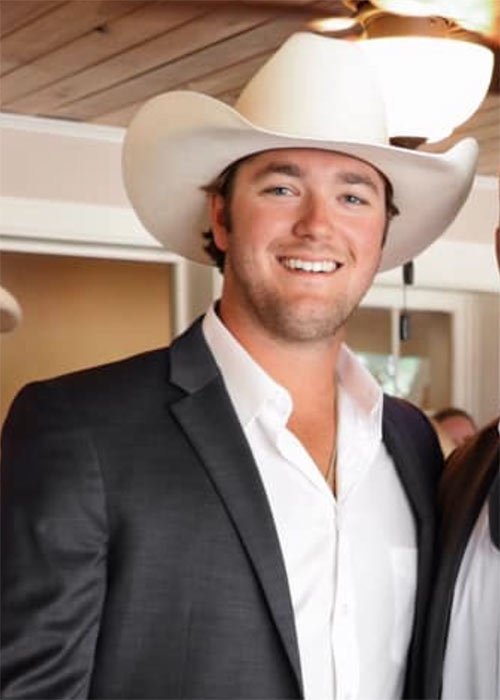 Mitchell Smith headshot - wearing suit and cowboy hat