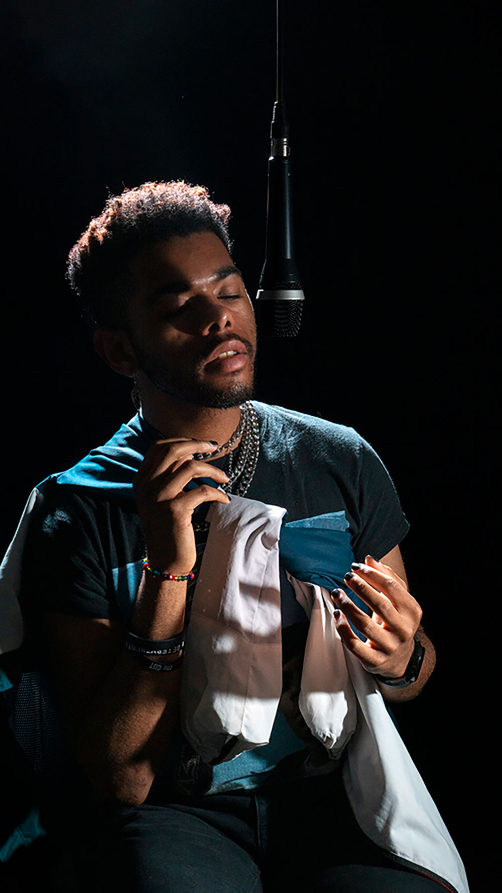 A photograph of a man singing into a microphone.