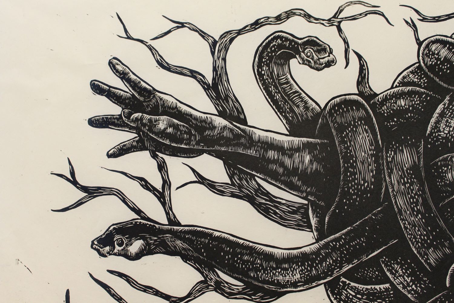 wood cut print of snakes and hands