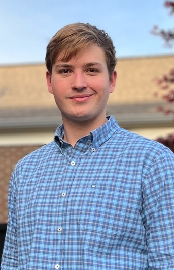 Drennan Allen smiling with a blue plaid button-up shirt on.