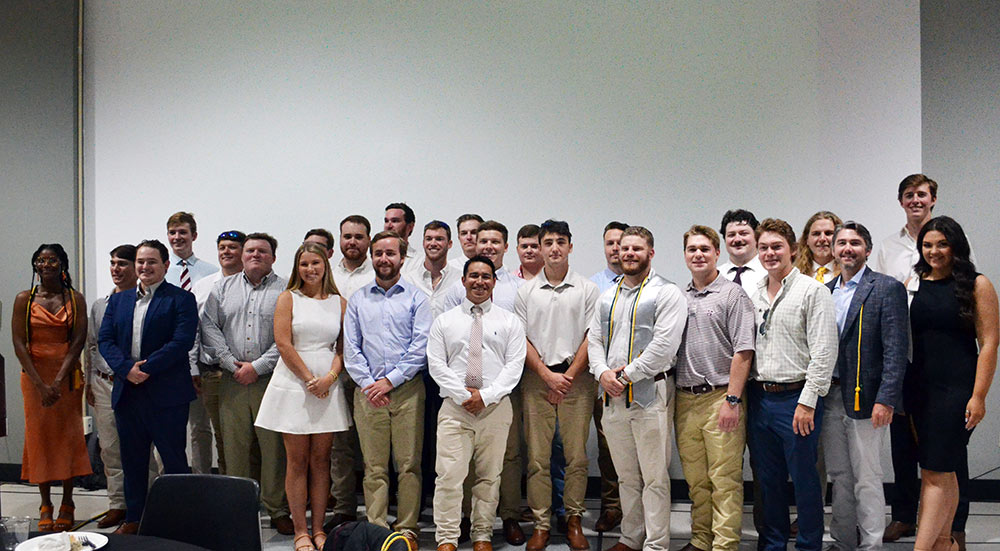 Building construction science seniors pose for group photo at reception