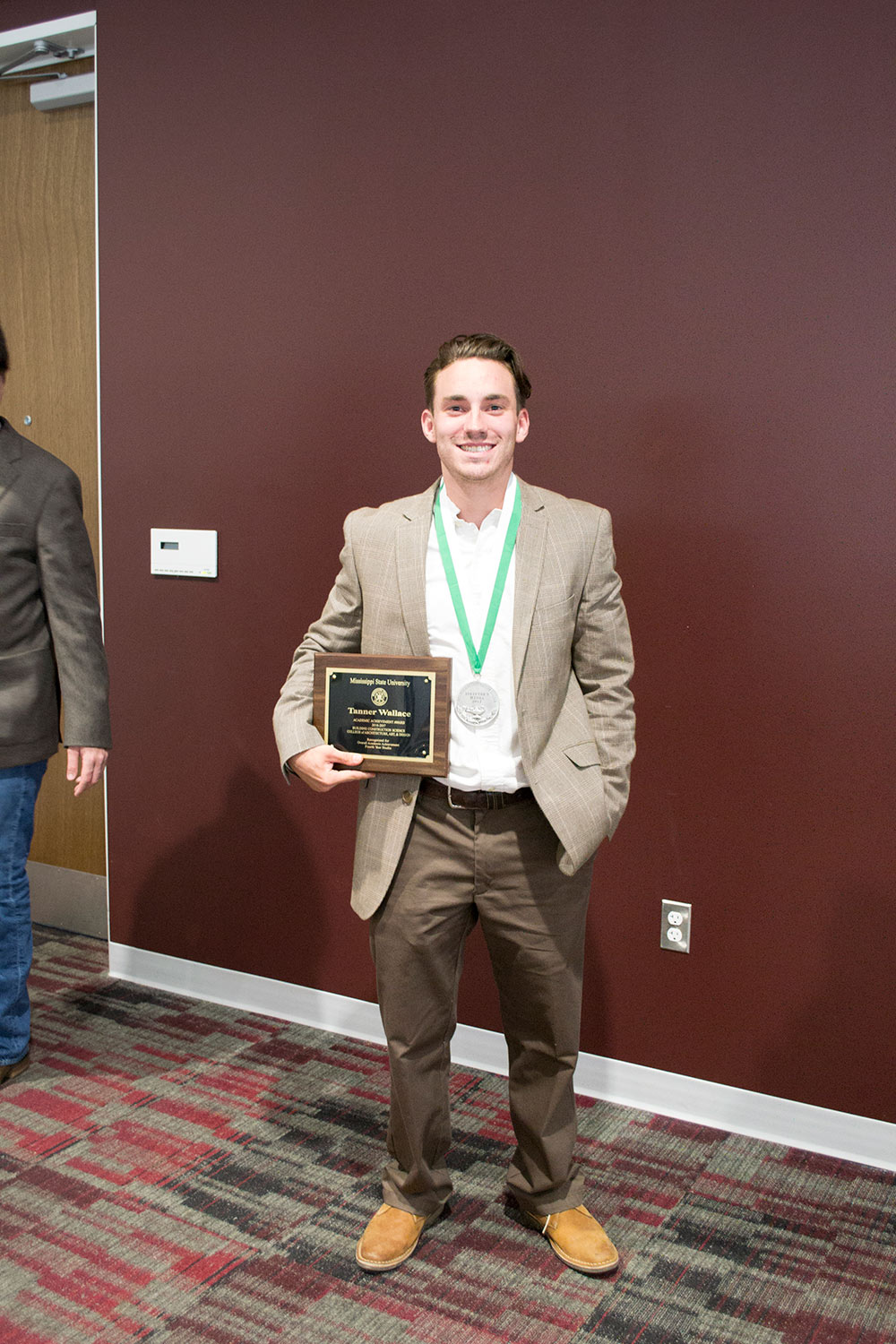 Tanner Wallace holds plaque