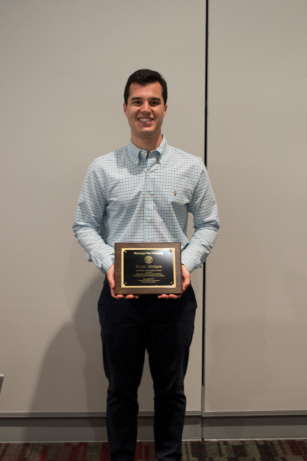 Evan Hodges holds award