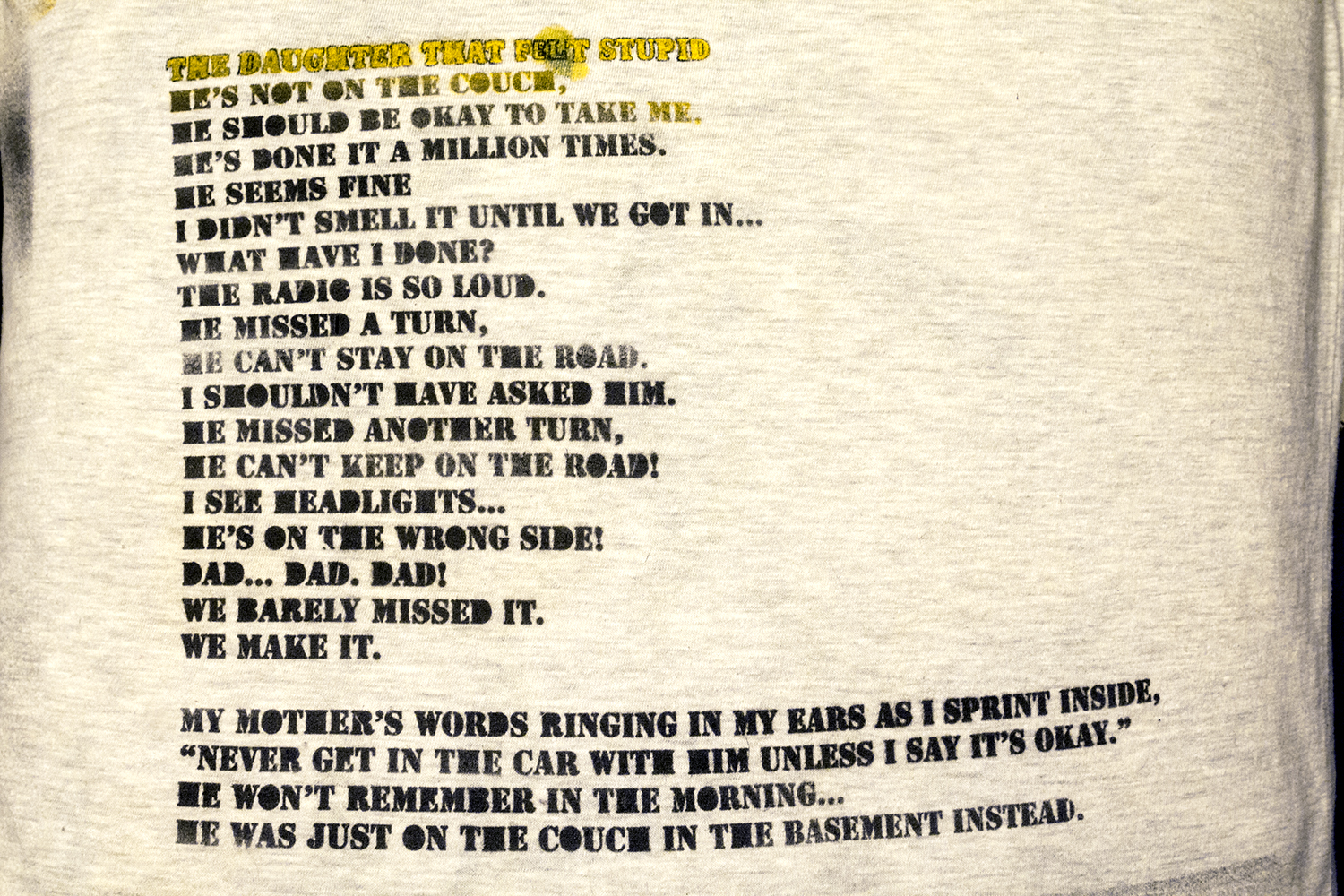 detail of poem on pillow: THE DAUGHTER THAT FLET STUPID HE’S NOT ON THE COUCH, HE SHOULD BE OKAY TO TAKE ME. HE’S DONE IT A MILLION TIMES. HE SEEMS FINE I DIDN’T SMELL IT UNTIL WE GOT IN… WHAT HAVE I DONE? THE RADIO IS SO LOUD. HE MISSED A TURN, HE CAN’T STAY ON THE ROAD. I SHOULDN’T HAVE ASKED HIM. HE MISSED ANOTHER TURN, HE CAN’T KEEP ON THE ROAD! I SEE HEADLIGHTS… HE’S ON THE WRONG SIDE! DAD… DAD. DAD! WE BARELY MISSED IT. WE MAKE IT.   MY MOTHER’S WORDS RINGING IN MY EARS AS I SPRINT INSIDE, “NEVER GET IN THE CAR WITH HIM UNLESS I SAY IT’S OKAY.” HE WON’T REMEMBER IN THE MORNING… HE WAS JUST ON THE COUCH IN THE BASEMENT INSTEAD.