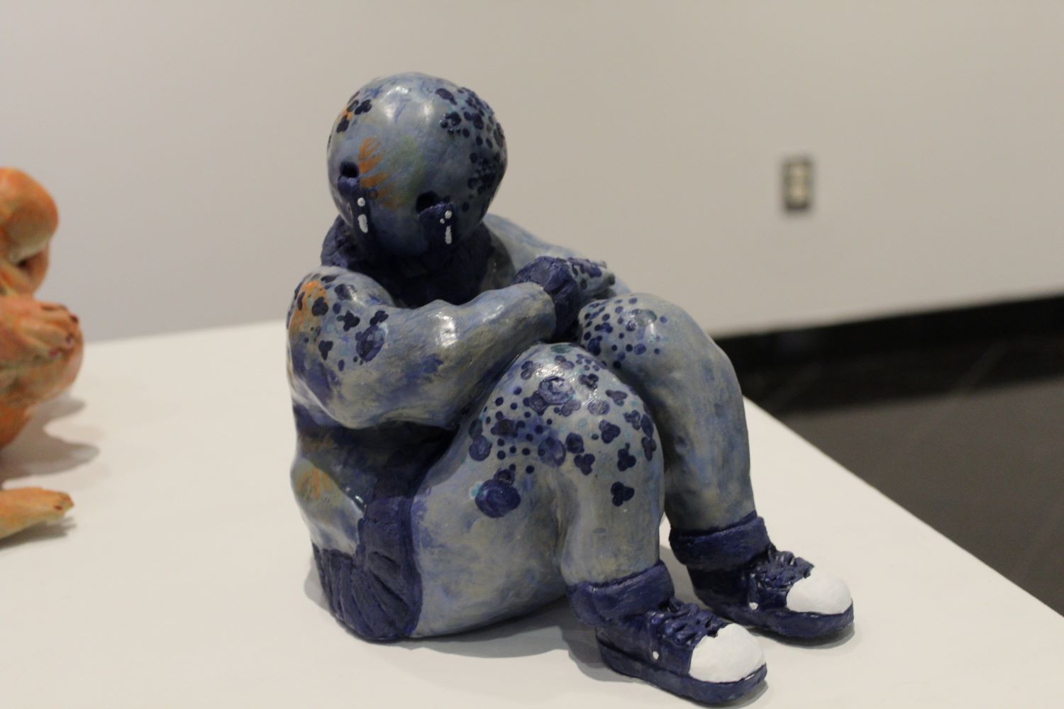 ceramic piece of a man curled up 