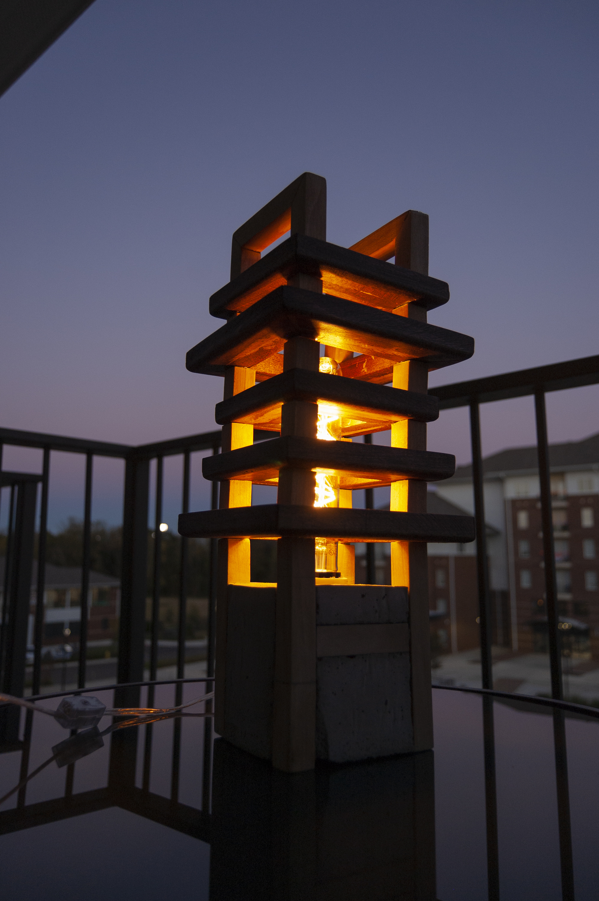 Hand crafted lamp with wood slats going both horizontally and vertically to create a pattern.