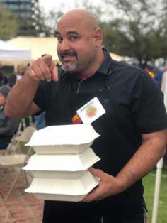 restaurant worker holding paper to-go boxes