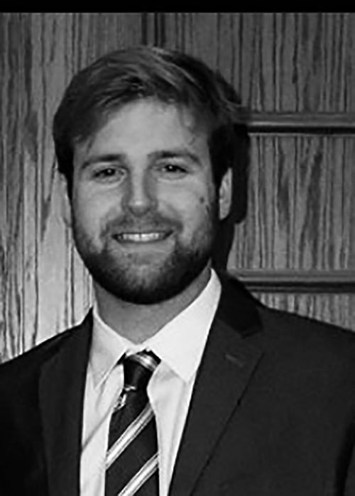 black and white headshot of Tyler Seal wearing suit and tie