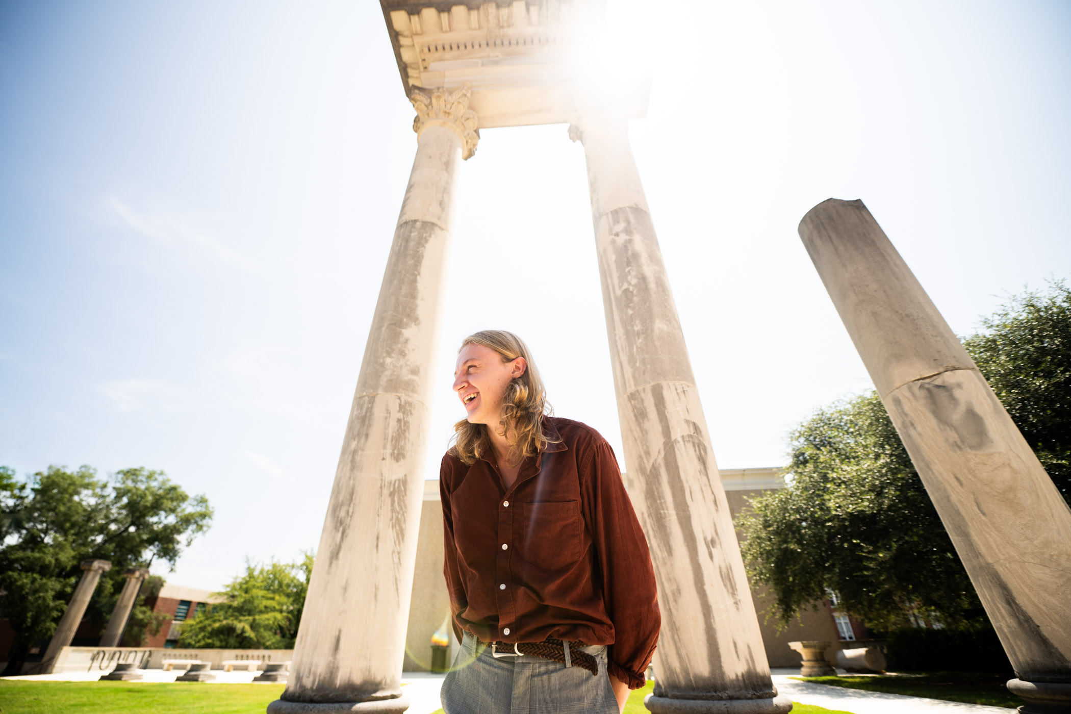 Aidan Taylor stands facing the side with columns behind him